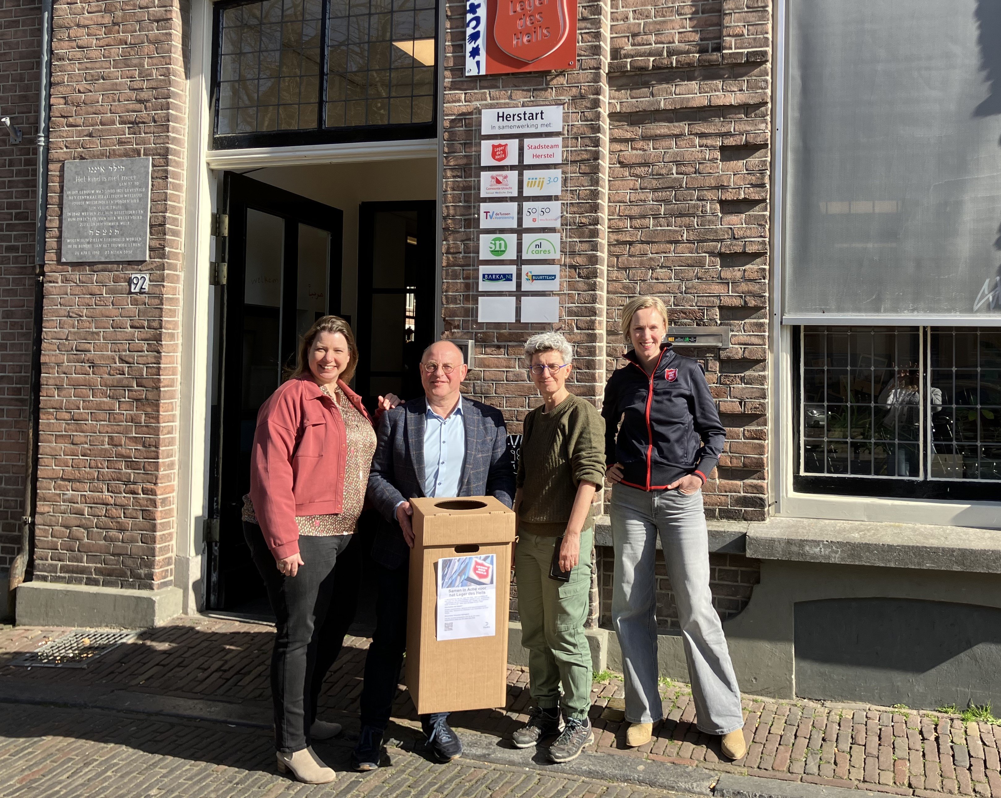 a group of people posing for a photo outside a building