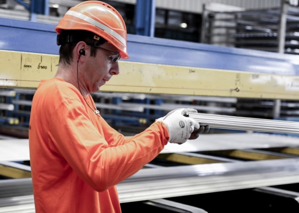 a man wearing a hard hat and gloves working on a piece of equipment