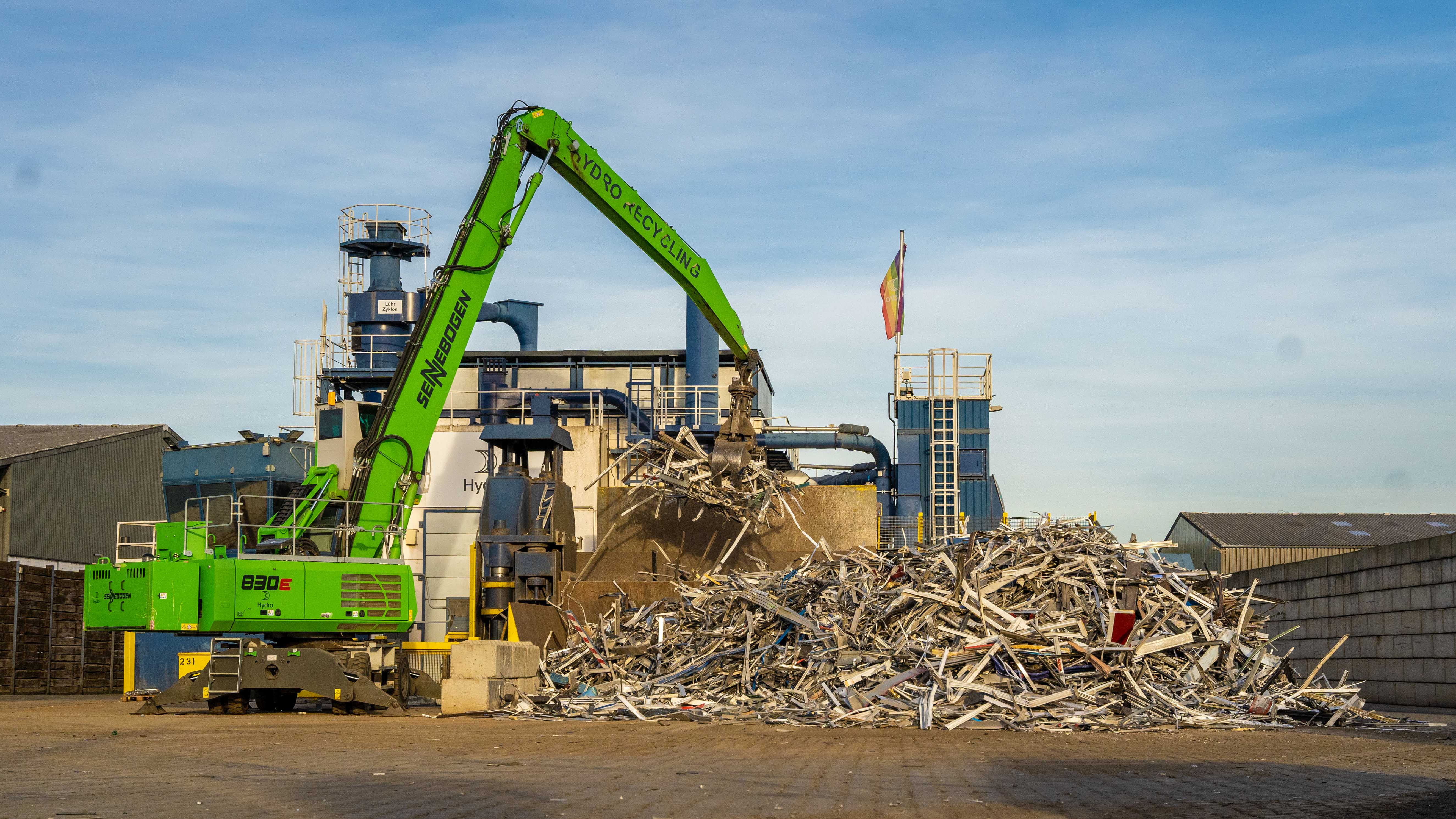 A crane lifting a pile of aluminium scrap
