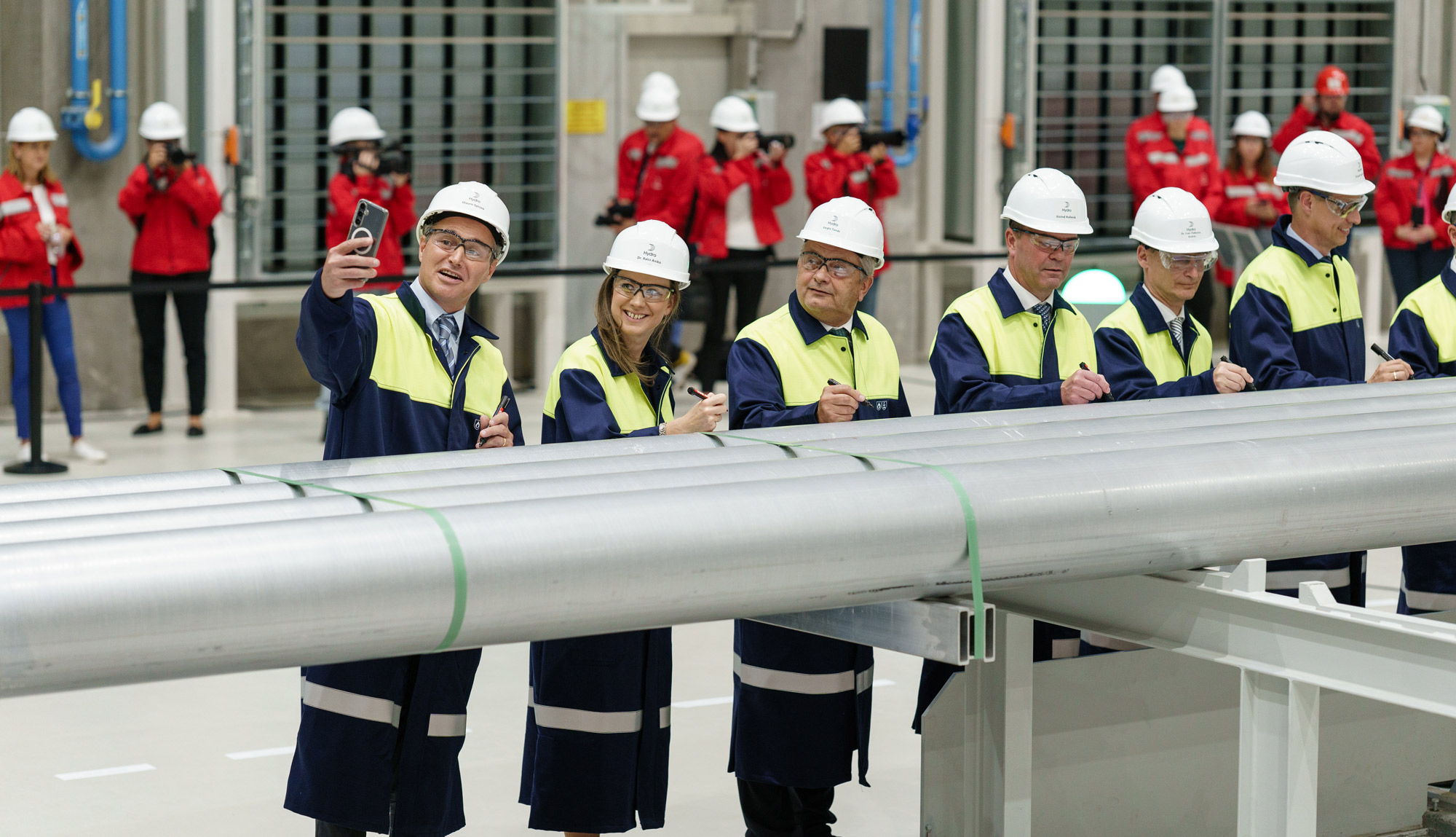 Signing of an extrusion billet to mark the opening of the new recycling unit in Székesfehérvár: (from left) Mauro Spizzo (Head of Hydro Extrusion Europe region East), Dr. Anikó Raisz (secretary of state for Environmental Affairs and the Circular Economy), Tamás Vargha (member of the National Assembly (MP) for Székesfehérvár), Eivind Kallevik (Hydro CEO), Dr. András Cser-Palkovics (member of the National Assembly (MP) for Székesfehérvár) and Frank Iepema (Plant Manager).