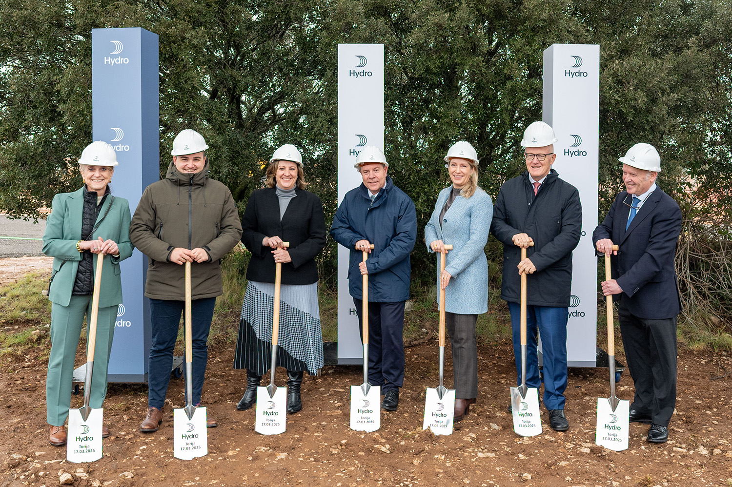 a group of people wearing hardhats and holding shovels