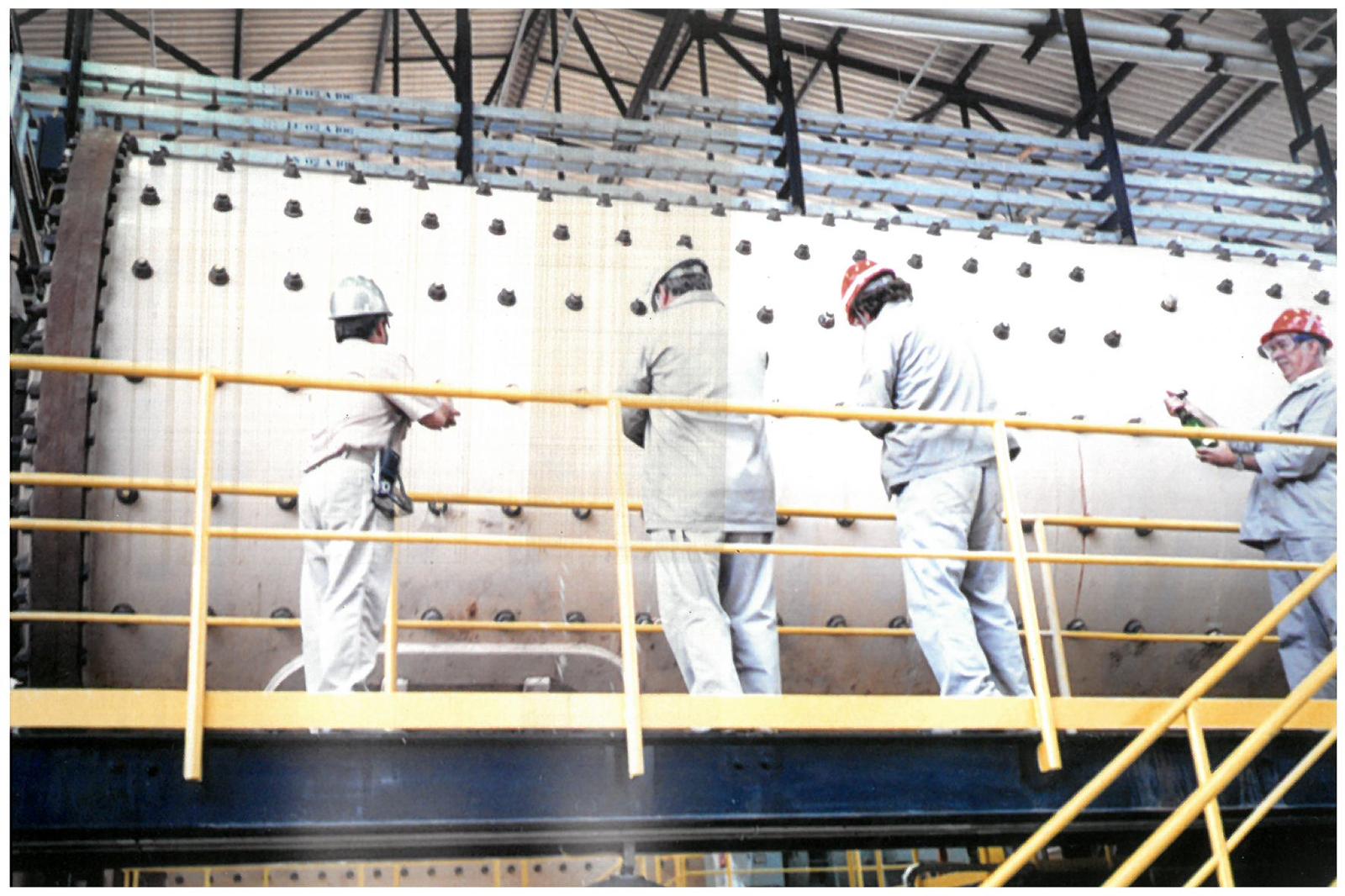 a group of people in white protective gear working on a metal frame