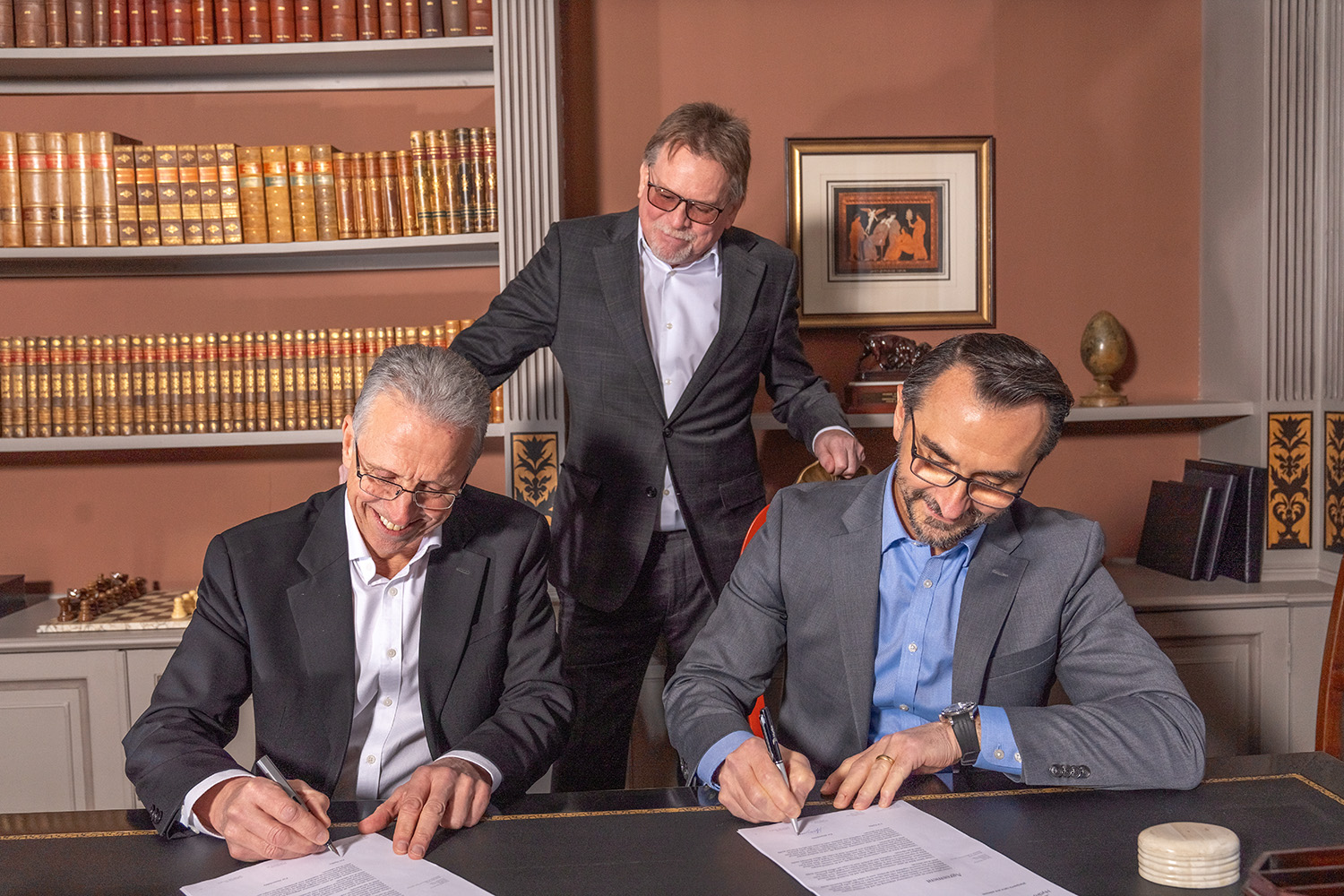 a group of men signing papers