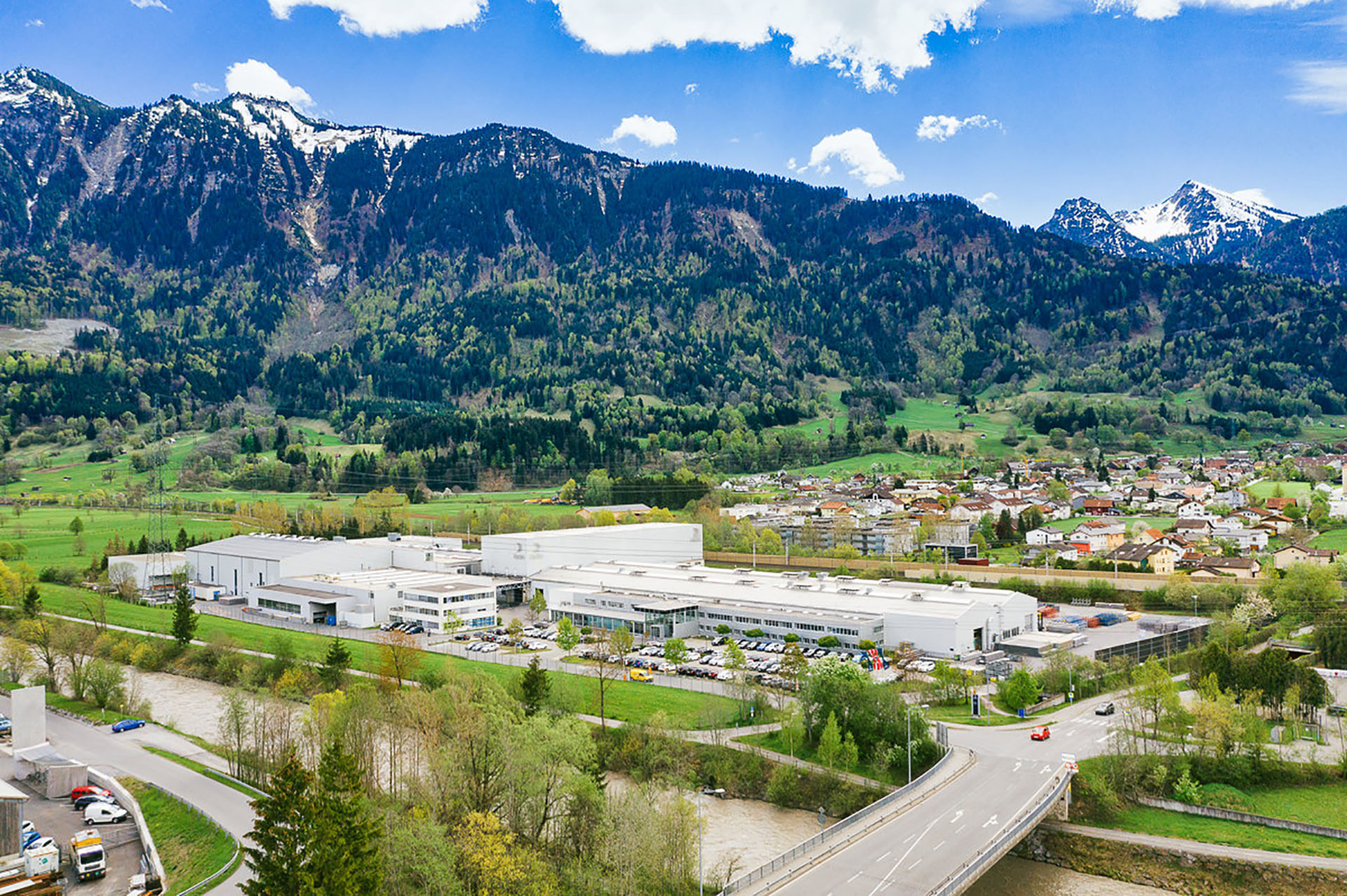 a large building with a road and mountains in the background