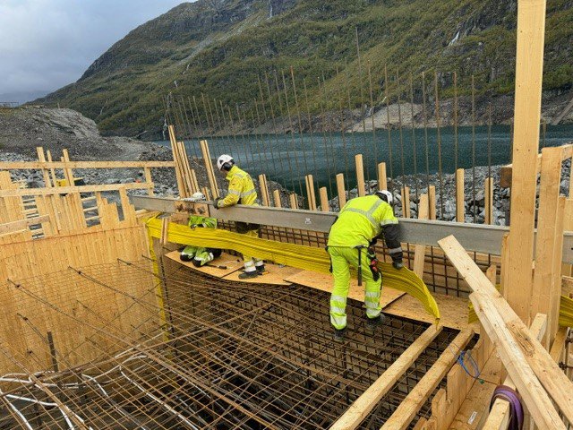 men in yellow jackets working on a construction site