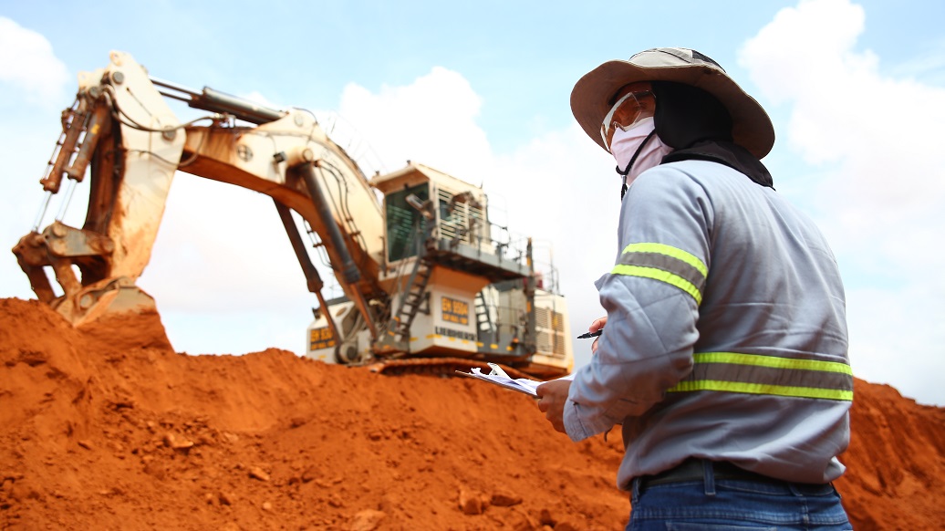 a man standing next to a bulldozer